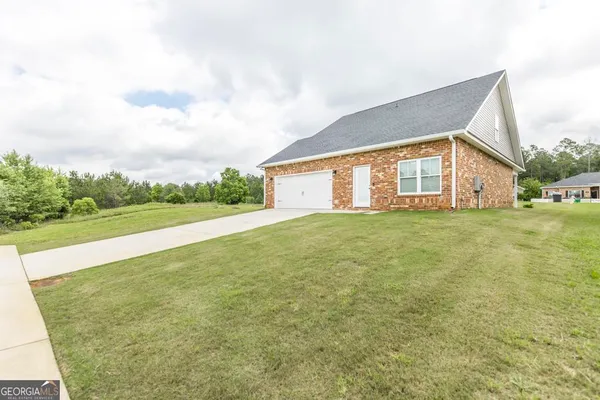 a view of a house with a big yard and large trees