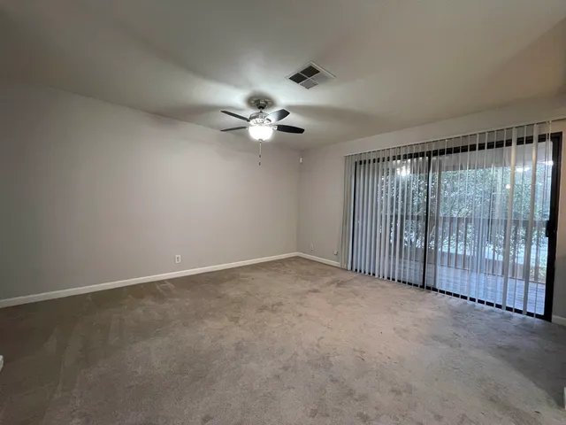 an empty room with chandelier fan