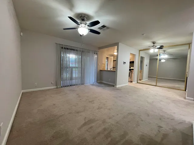 a view of an empty room with a chandelier fan