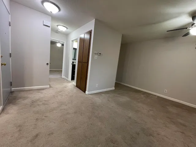 an empty room with closet and a chandelier fan