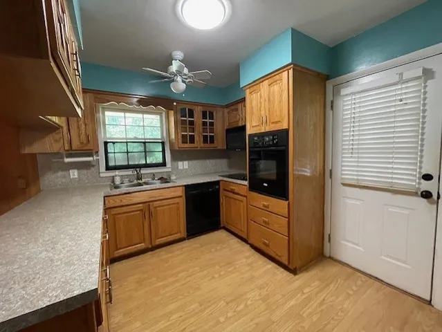 a large kitchen with stainless steel appliances granite countertop a refrigerator a sink dishwasher a stove and white countertops with wooden floor