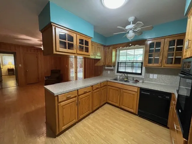 a kitchen with stainless steel appliances granite countertop a sink and dishwasher a stove top oven with wooden floor