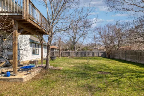 a view of a house with a big yard and large tree