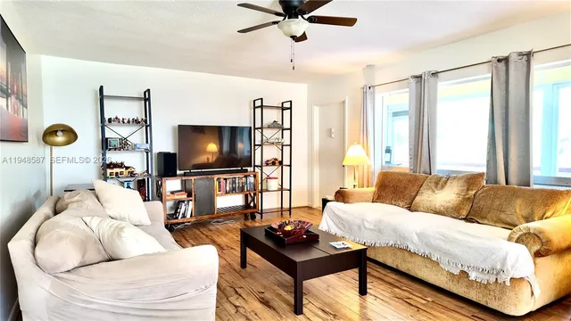 a living room with furniture and a flat screen tv with wooden floor