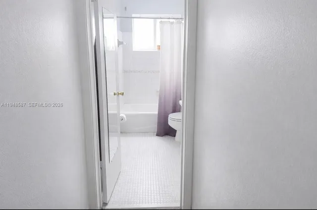 a bathroom with a granite countertop toilet and a shower
