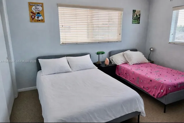 a bedroom with two beds and a window