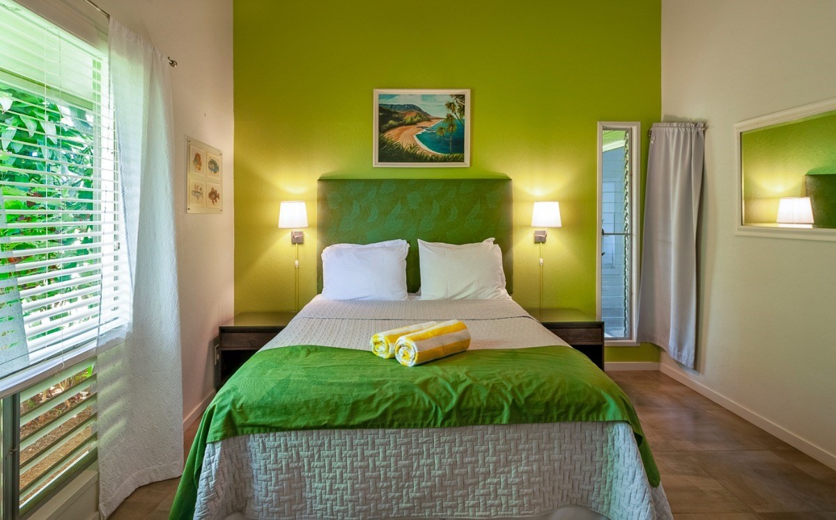 3880 Wyllie Road, Unit 1A Princeville, HI 96722 - Photo 16 of 22 a bedroom with a bed and wooden floor