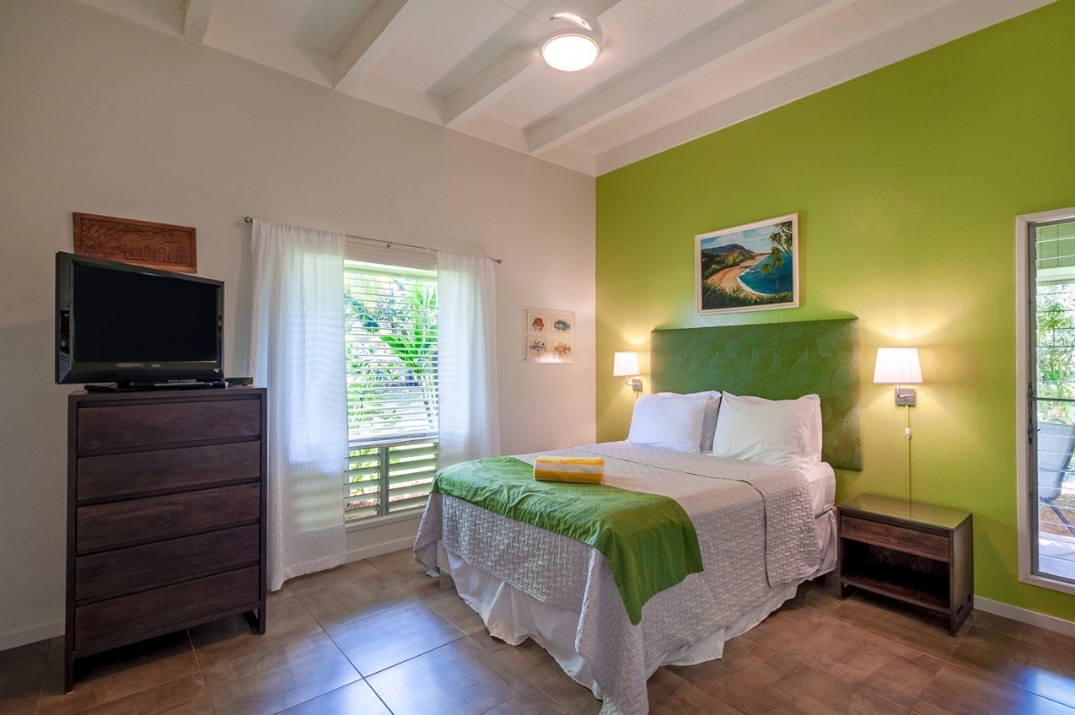 3880 Wyllie Road, Unit 1A Princeville, HI 96722 - Photo 17 of 22 a bedroom with a bed and a flat screen tv