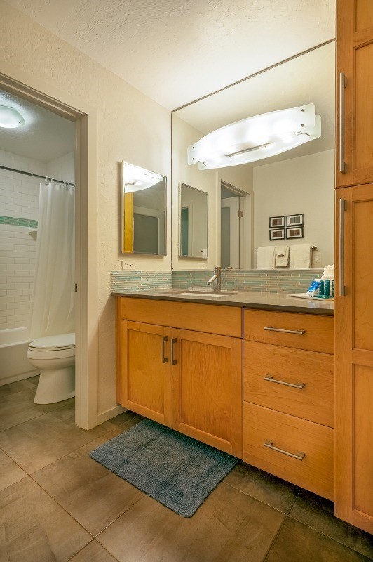 3880 Wyllie Road, Unit 1A Princeville, HI 96722 - Photo 19 of 22 a bathroom with a granite countertop sink mirror and toilet