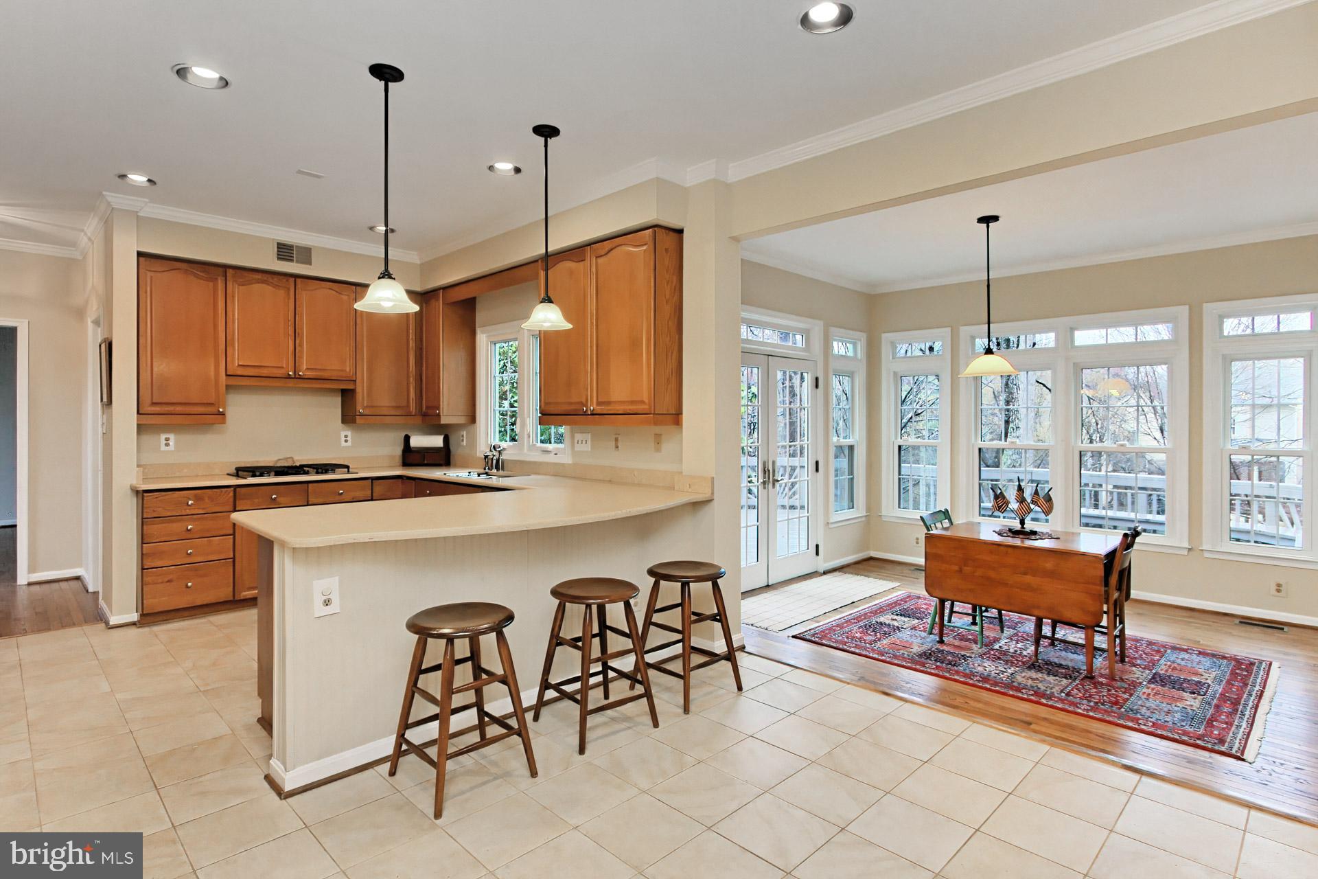8126 Ridge Creek Way Springfield, VA 22153 - Photo 14 of 50 a large kitchen with a table chairs refrigerator and cabinets