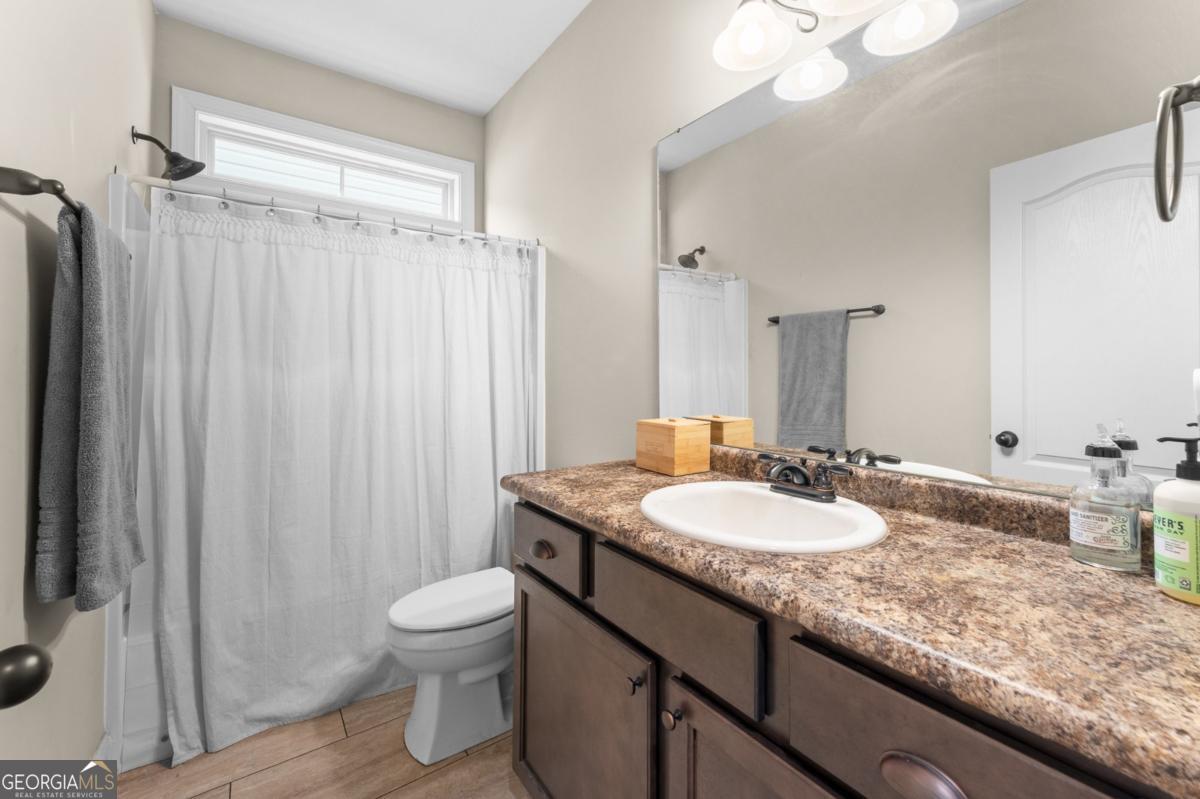 161 Laguna Way Savannah, GA 31405 - Photo 7 of 33 a bathroom with a granite countertop sink toilet a mirror a vanity and shower