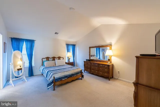 a spacious bedroom with a bed and a window