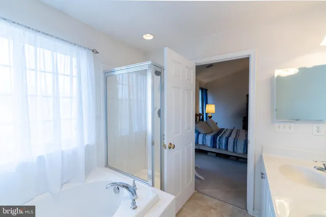 a en suite spacious bathroom with a tub shower and bedroom