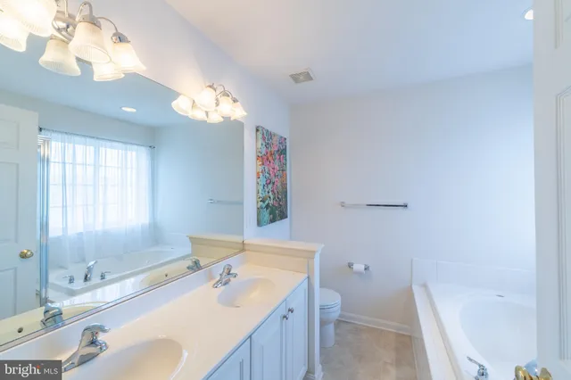 a bathroom with a tub sink and a mirror