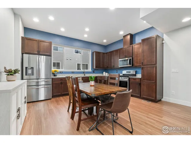 a kitchen with stainless steel appliances kitchen island granite countertop a refrigerator and a stove top oven