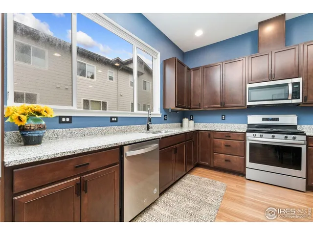 a kitchen with granite countertop a stove a sink and a microwave