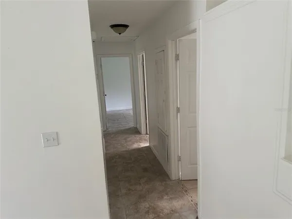 a view of a hallway with wooden shelves