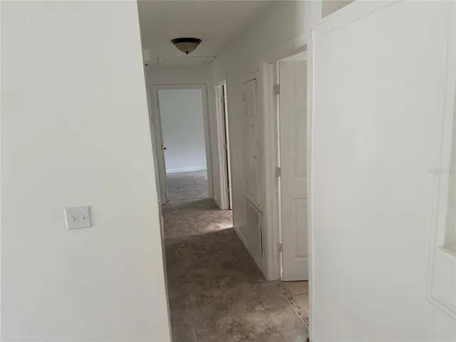 a view of a hallway with wooden shelves
