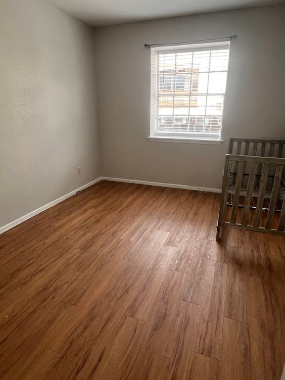 307 East 31st Street, Unit 208 Austin, TX 78705 - Photo 23 of 25 an empty room with wooden floor and windows