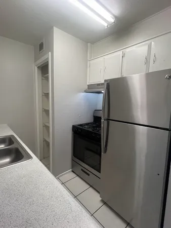 a kitchen with a refrigerator and a stove