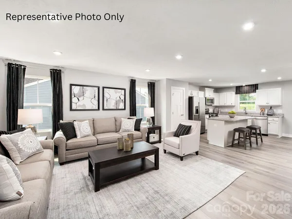 a living room with furniture and view of kitchen