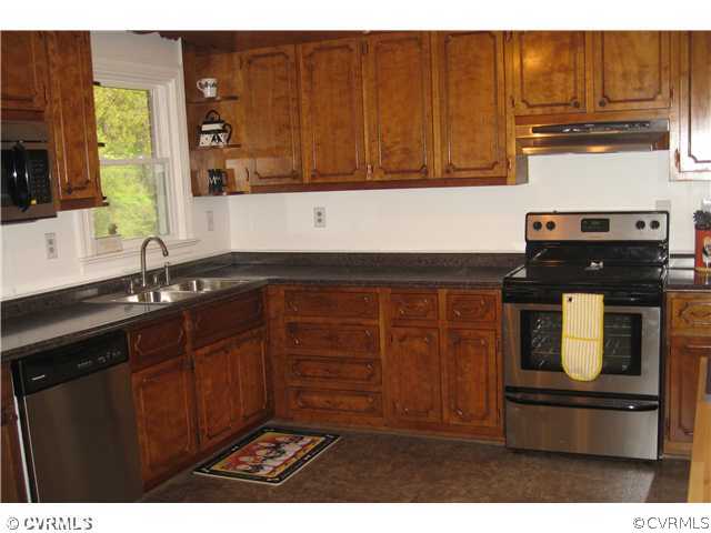 11238 Hanover Courthouse Road Mechanicsville, VA 23116 - Photo 3 of 12 a kitchen with granite countertop wooden cabinets and a sink