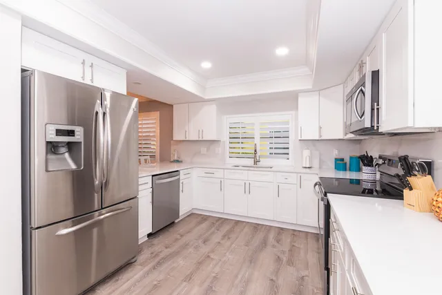 a kitchen with a refrigerator stove top oven and sink
