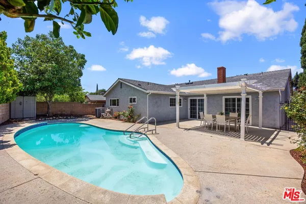a view of a house with swimming pool and sitting area