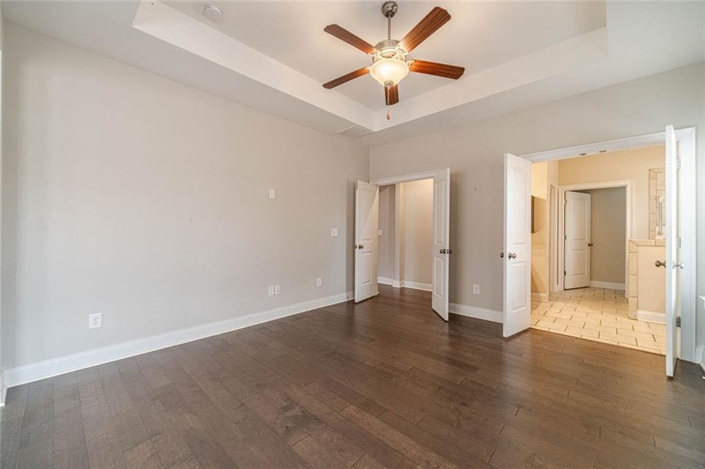 347 Villa Park Circle Stone Mountain, GA 30087 - Photo 11 of 25 an empty room with wooden floor and a ceiling fan