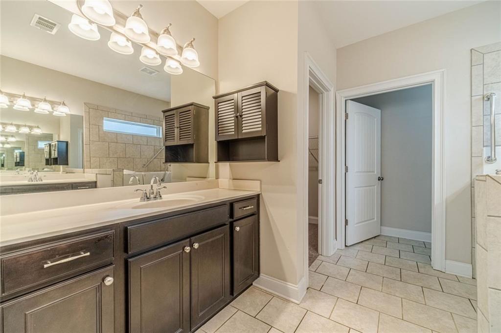 347 Villa Park Circle Stone Mountain, GA 30087 - Photo 13 of 25 a bathroom with a sink a large mirror and a shower