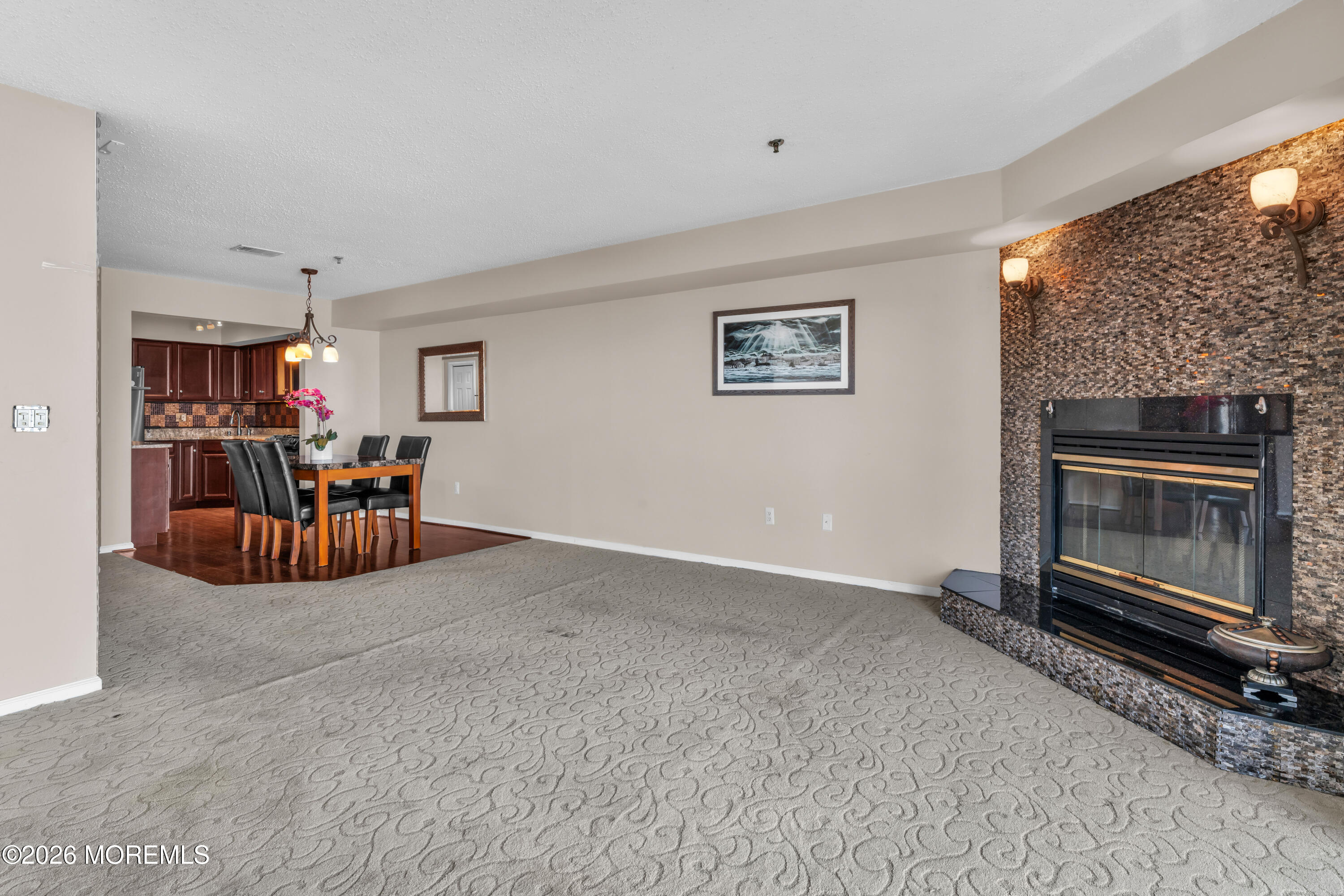 135 1st Street, Unit 1E Keyport, NJ 07735 - Photo 18 of 40 a living room with furniture a fireplace and a flat screen tv