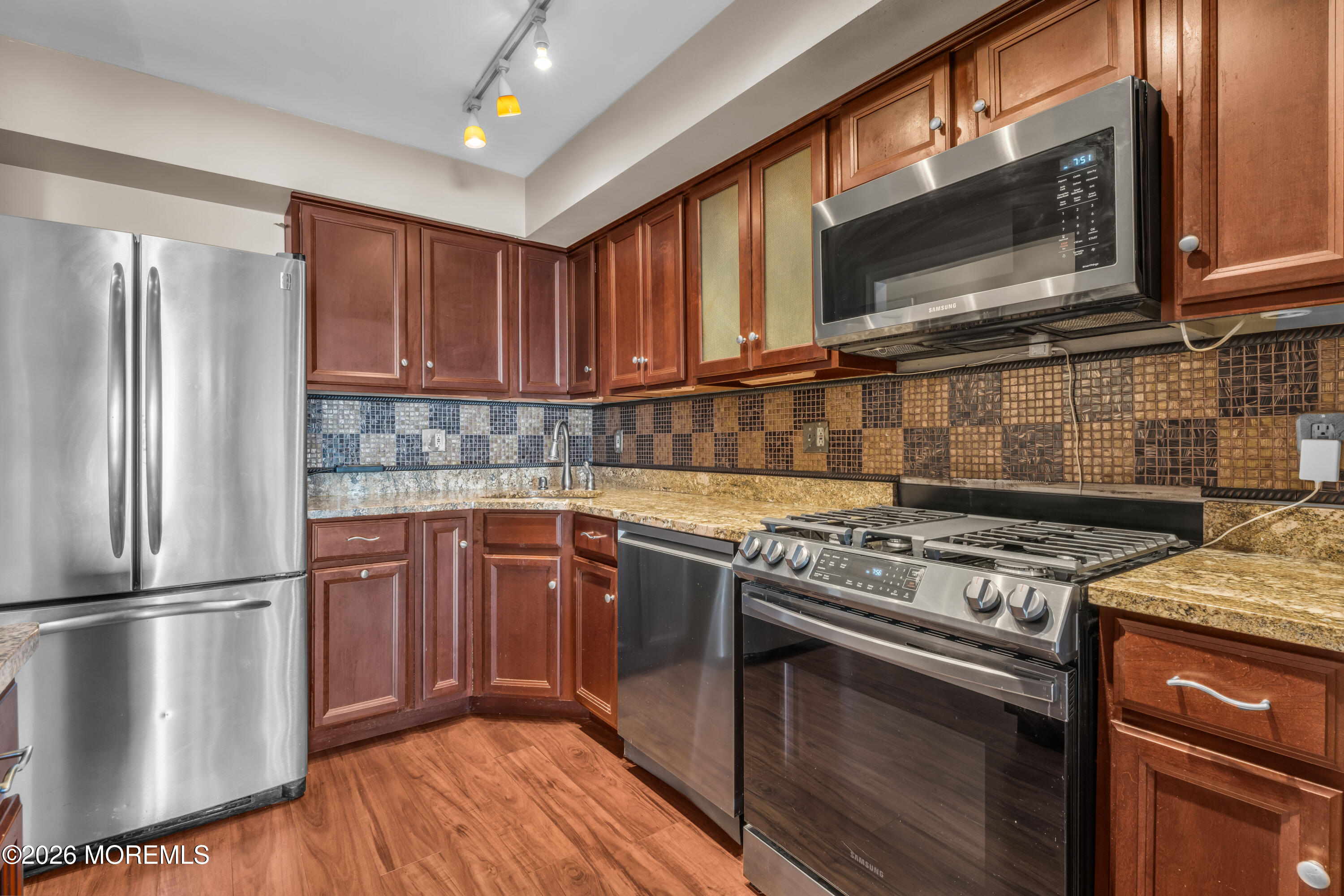 135 1st Street, Unit 1E Keyport, NJ 07735 - Photo 21 of 40 a kitchen with stainless steel appliances granite countertop a stove a microwave and a refrigerator