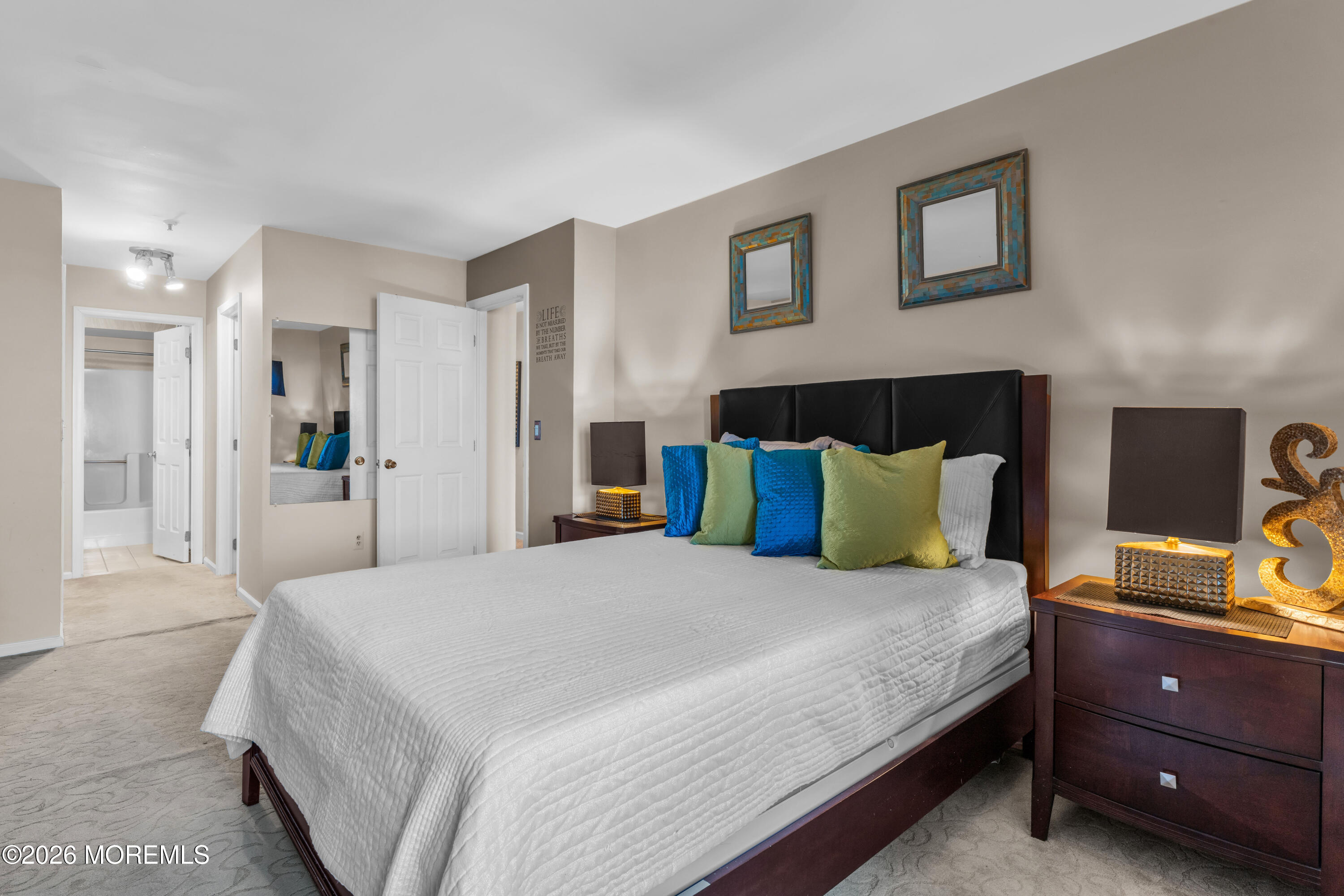 135 1st Street, Unit 1E Keyport, NJ 07735 - Photo 27 of 40 a bedroom with a bed a couch and a view of en suite bathroom