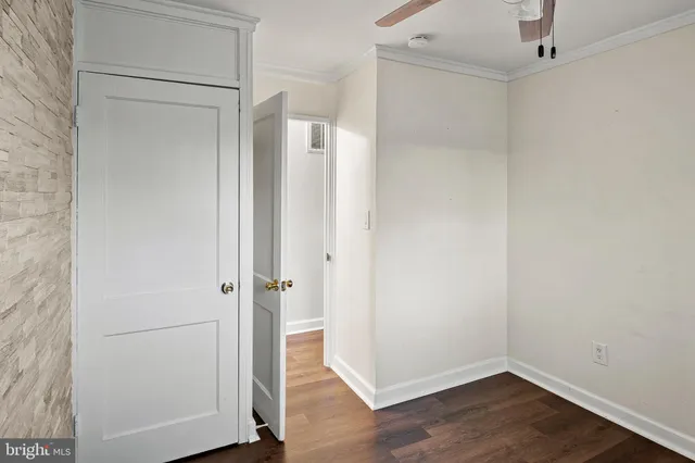 a view of wooden floor and a chandelier fan in a room