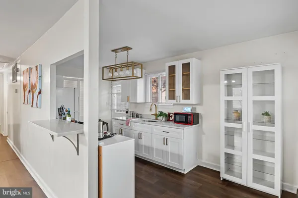 a kitchen with cabinets and wooden floor
