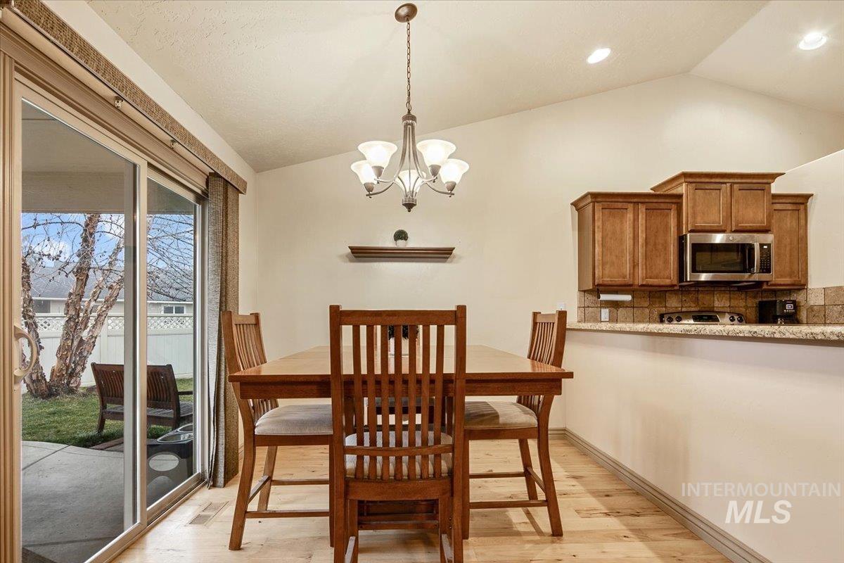 1513 Fairway Street Middleton, ID 83644 - Photo 6 of 20 Dining area featuring vaulted ceiling, a chandelier, and light wood finished floors