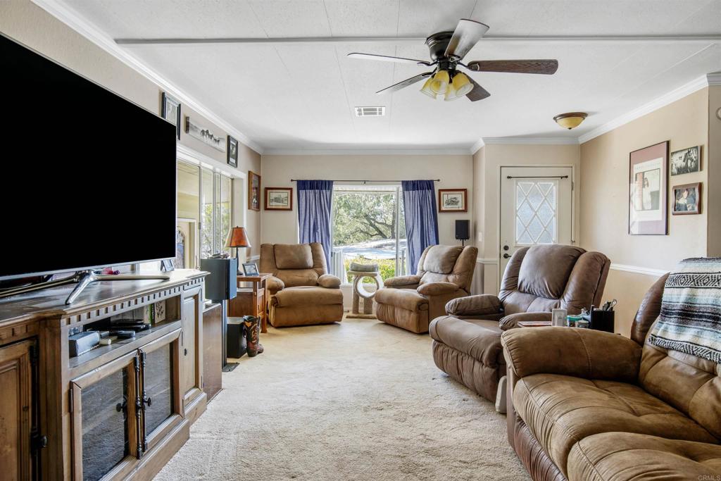 18218 Paradise Mountain Road Valley Center, CA 92082 - Photo 9 of 53 a living room with furniture and a flat screen tv