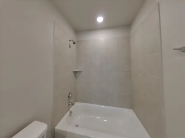 a bathroom with a white bath tub and a toilet