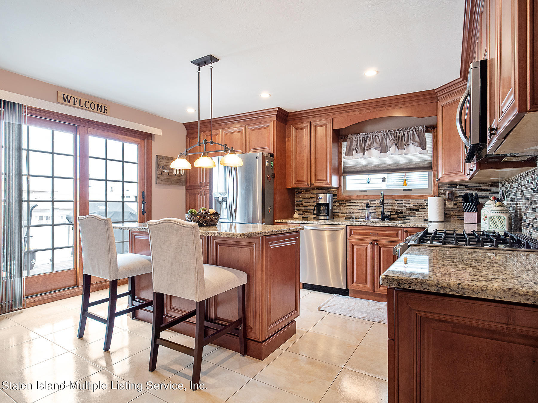 84 Stack Drive Staten Island, NY 10312 - Photo 11 of 29 a kitchen with a table chairs microwave and cabinets