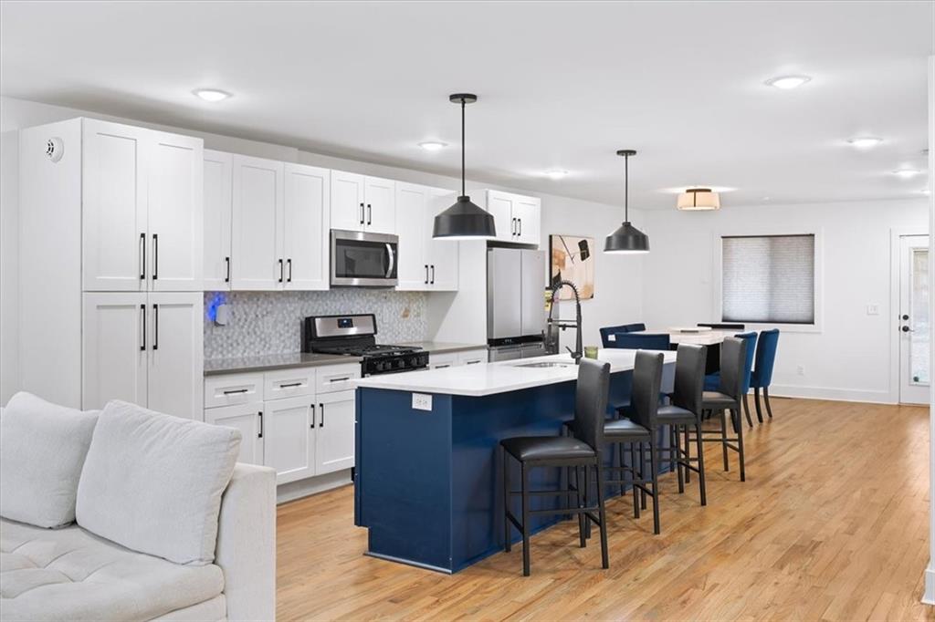 1846 Rogers Avenue Southwest Atlanta, GA 30310 - Photo 16 of 46 a kitchen with stainless steel appliances kitchen island granite countertop a sink a stove a dining table and chairs