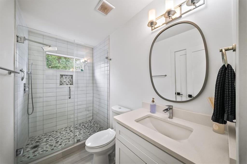 1846 Rogers Avenue Southwest Atlanta, GA 30310 - Photo 19 of 46 a bathroom with a sink a mirror a toilet and a shower