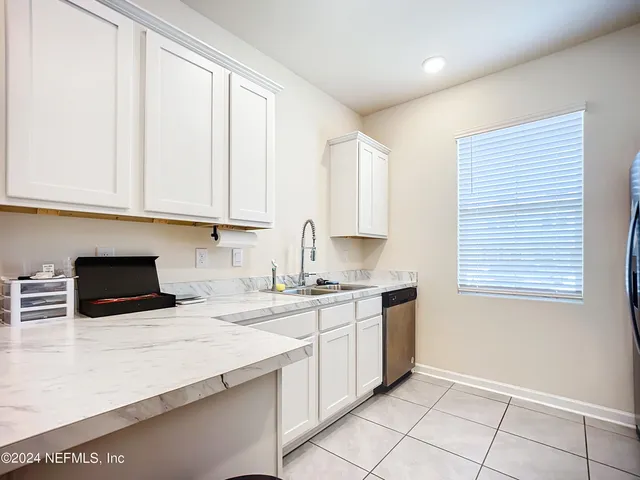 a kitchen with granite countertop a sink stove and cabinets
