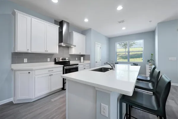 a kitchen with a white cabinets and chairs