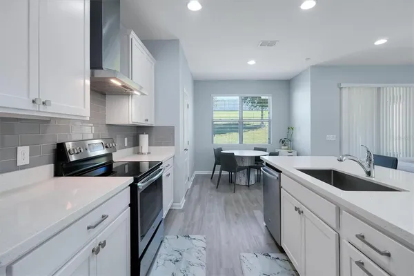 a kitchen with granite countertop white cabinets and white appliances