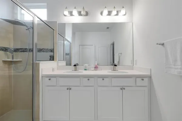 a bathroom with a double vanity sink and a mirror