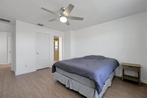 a spacious bedroom with a bed and a chandelier