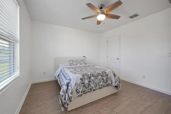 a bedroom with a bed and a ceiling fan