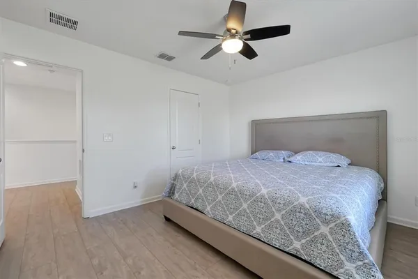 a bedroom with a bed and a ceiling fan