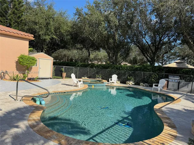 a view of a street with a cars parked and small park