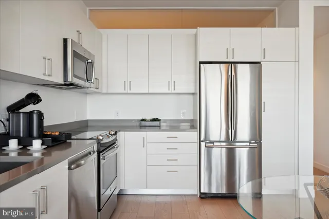 a kitchen with appliances a sink and cabinets